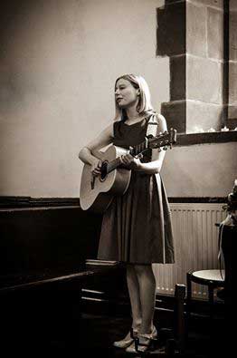 Rachel Purcell playing guitar and singing